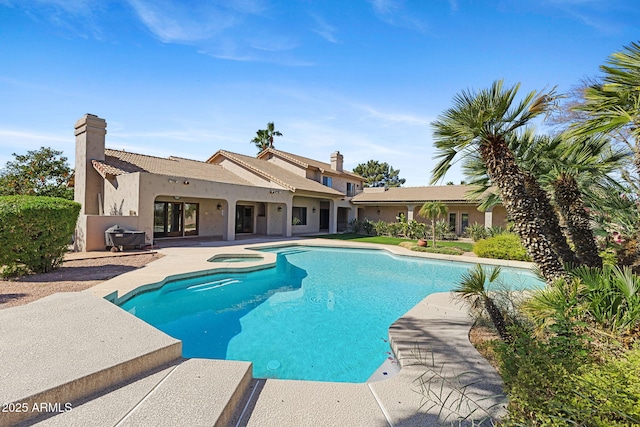 view of pool with a pool with connected hot tub and a patio