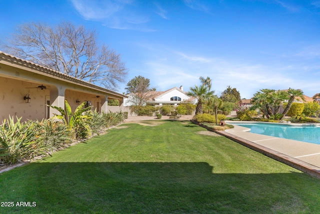 view of yard featuring a ceiling fan, a patio area, and an outdoor pool