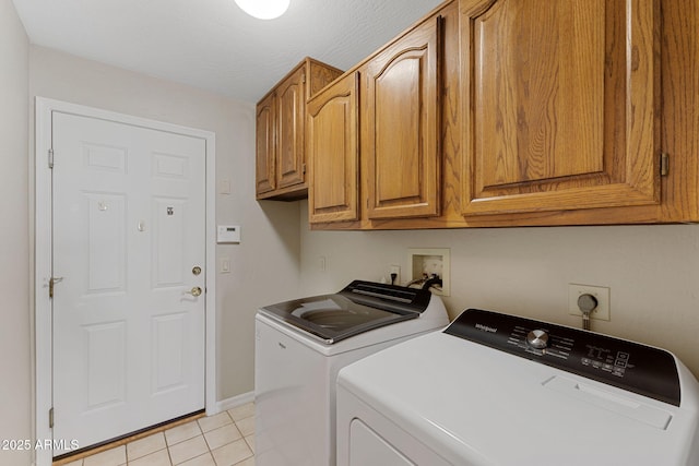 laundry room featuring cabinet space, washer and clothes dryer, baseboards, and light tile patterned floors