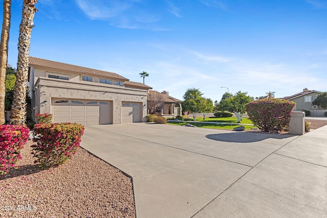 view of front of house featuring a garage, driveway, and stucco siding