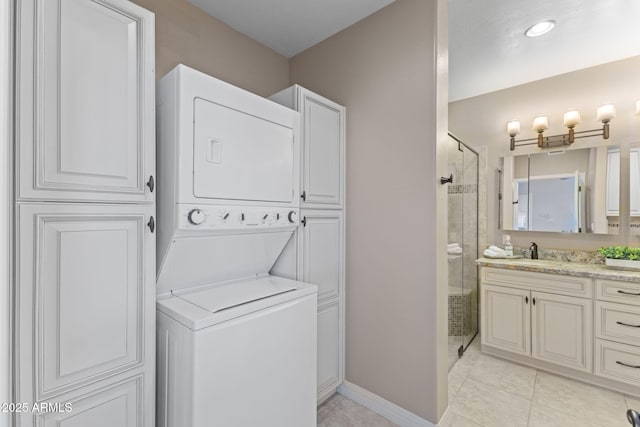 laundry room featuring stacked washer and clothes dryer, a sink, baseboards, and light tile patterned floors