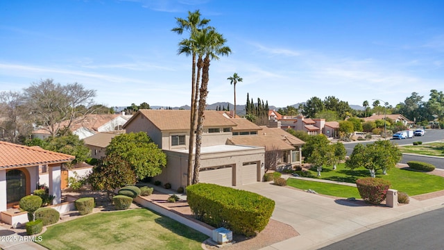 view of front of property with concrete driveway, stucco siding, a residential view, an attached garage, and a front yard