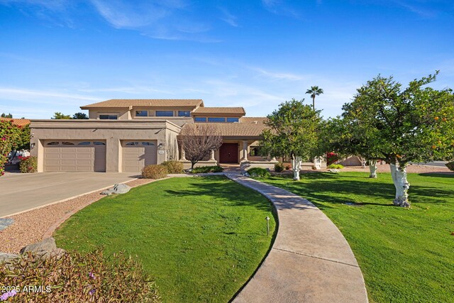 view of front of property featuring a garage, a front lawn, concrete driveway, and stucco siding