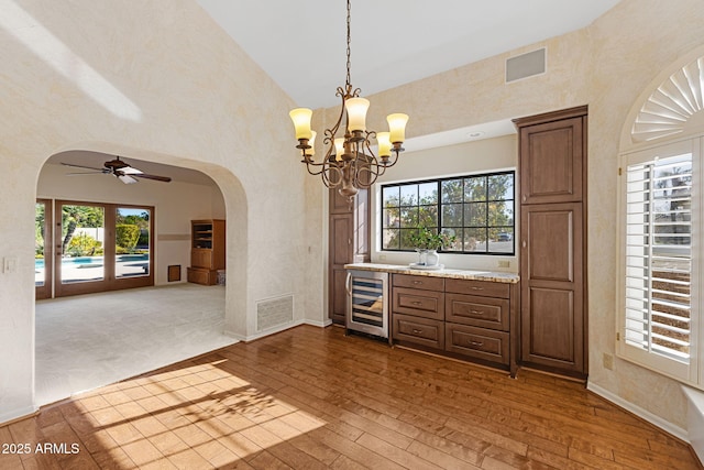 bar featuring visible vents, wine cooler, arched walkways, and dark wood-style flooring