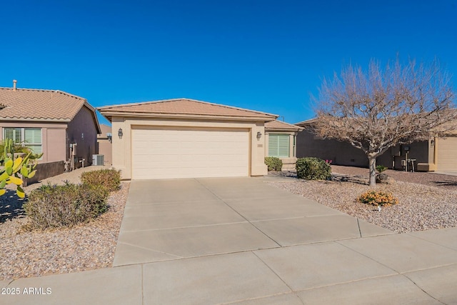 single story home featuring central AC unit and a garage