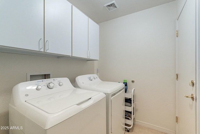 washroom featuring separate washer and dryer and cabinets