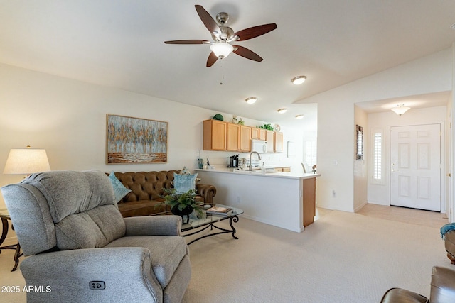 carpeted living room with ceiling fan, sink, and vaulted ceiling