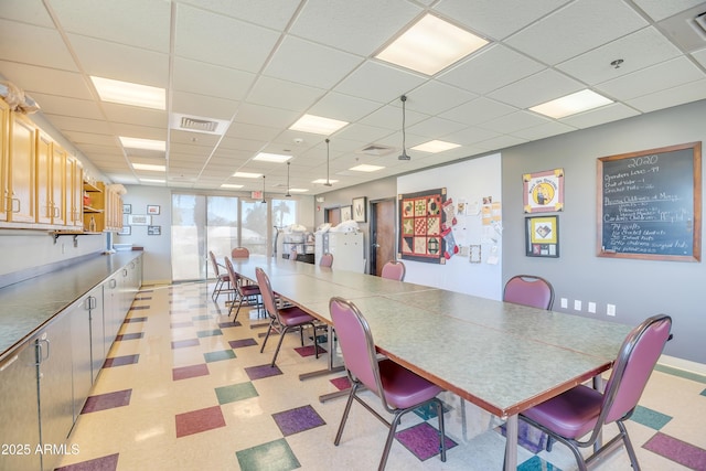 dining area featuring a drop ceiling