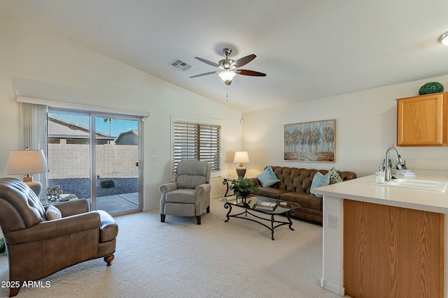 carpeted living room featuring ceiling fan, sink, and lofted ceiling