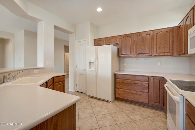 kitchen featuring light tile patterned floors, sink, and white appliances