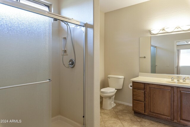 bathroom featuring vanity, toilet, tile patterned floors, and an enclosed shower