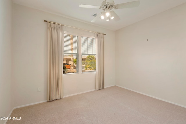 spare room with ceiling fan and light colored carpet