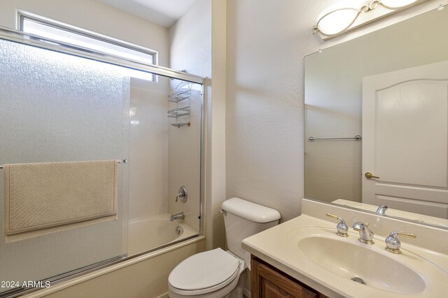 full bathroom featuring shower / bath combination with glass door, vanity, and toilet