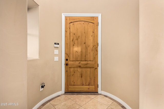 interior space with baseboards and light tile patterned floors