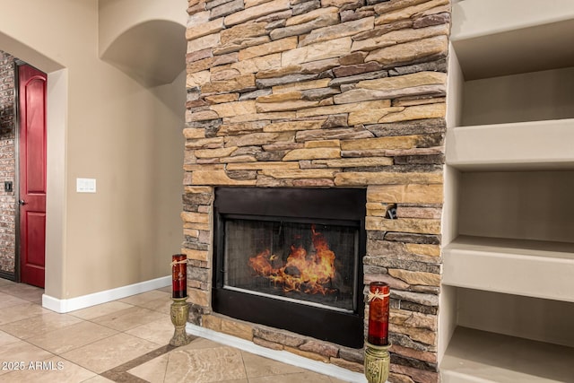 room details featuring baseboards and a fireplace