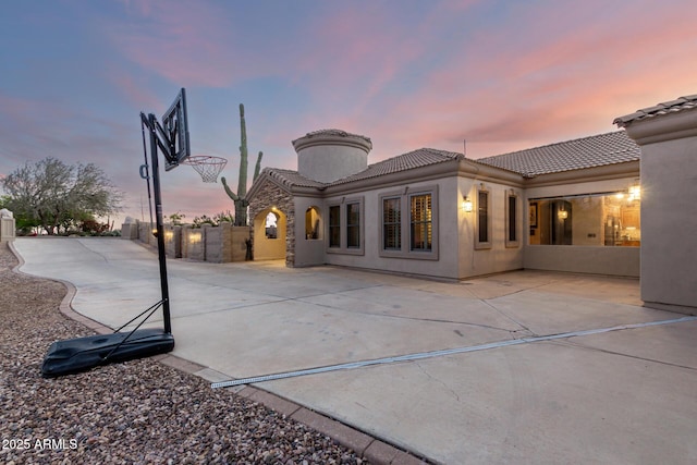rear view of property with a tiled roof and stucco siding
