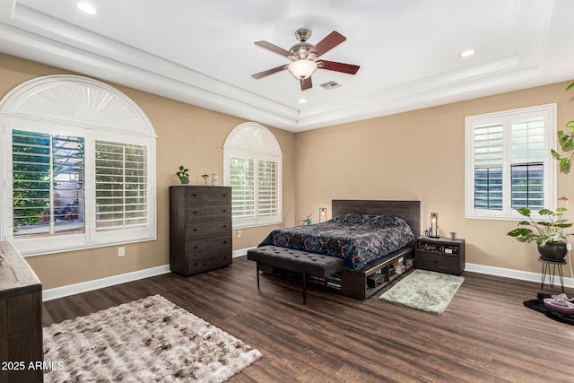 bedroom with visible vents, recessed lighting, a raised ceiling, and wood finished floors