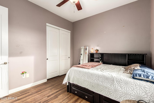 bedroom with baseboards, a ceiling fan, wood finished floors, and a closet