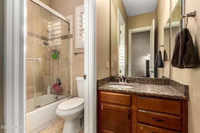 full bathroom with toilet, tile patterned floors, combined bath / shower with glass door, and vanity