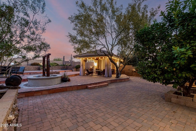 patio terrace at dusk with a gazebo and a fenced backyard