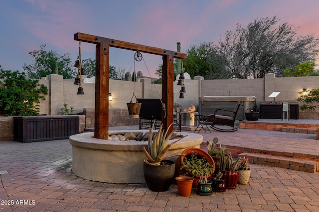 patio terrace at dusk with fence and an outdoor fire pit
