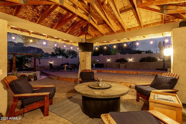 patio at night featuring a gazebo and a fenced backyard