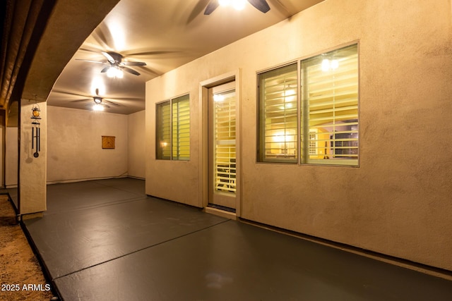 doorway to property featuring a ceiling fan, a patio, and stucco siding