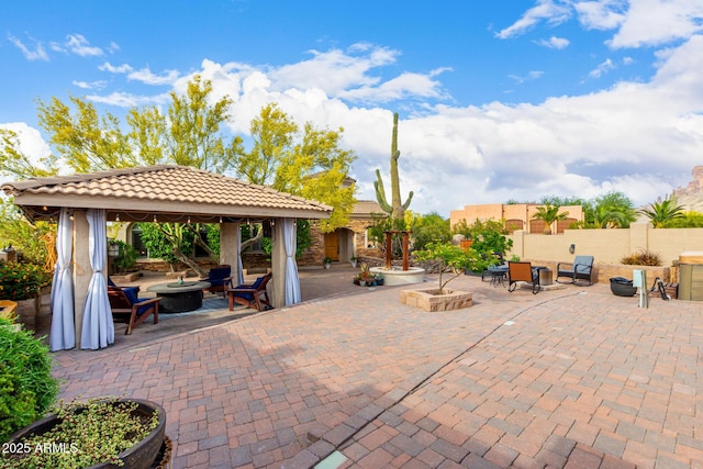 view of patio / terrace featuring a gazebo, fence, and an outdoor fire pit