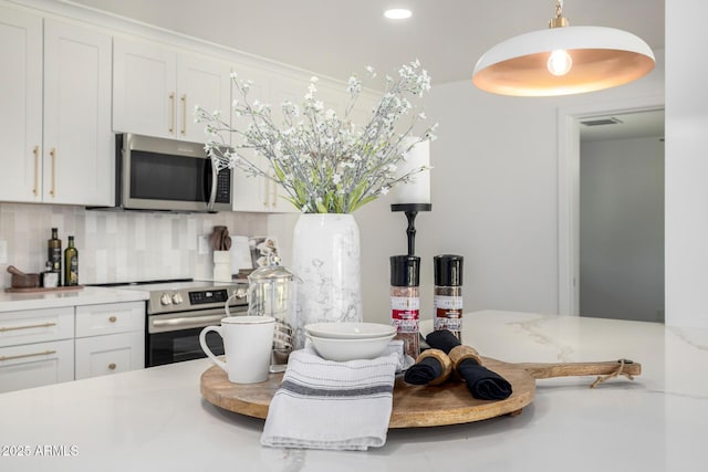 215 W Ruth Ave, Phoenix, AZ 85021 - kitchen featuring stainless steel appliances, tasteful backsplash, light countertops, white cabinets, and hanging light fixtures