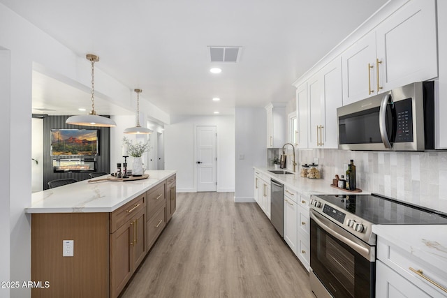 215 W Ruth Ave, Phoenix, AZ 85021 - kitchen featuring stainless steel appliances, light wood-type flooring, tasteful backsplash, white cabinets, and light stone counters