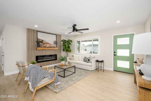 living area featuring recessed lighting, wood finished floors, ceiling fan, and a glass covered fireplace