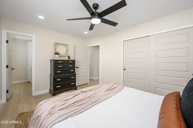 bedroom featuring a closet, baseboards, light wood finished floors, and recessed lighting