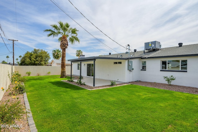 rear view of property featuring central air condition unit, a fenced backyard, stucco siding, a yard, and a patio area