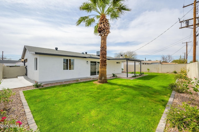 rear view of property featuring a fenced backyard, stucco siding, a patio, and a yard