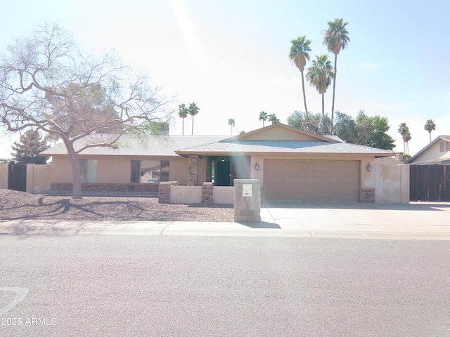 ranch-style house with a garage, driveway, fence, and stucco siding