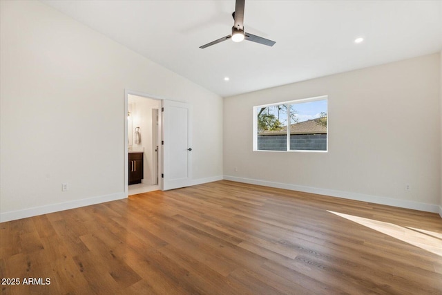 unfurnished bedroom featuring ceiling fan, lofted ceiling, wood-type flooring, and ensuite bathroom