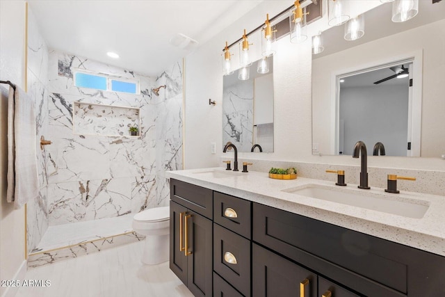 bathroom with a tile shower, vanity, and toilet