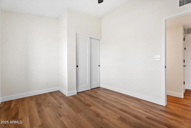 unfurnished bedroom featuring wood-type flooring and a closet