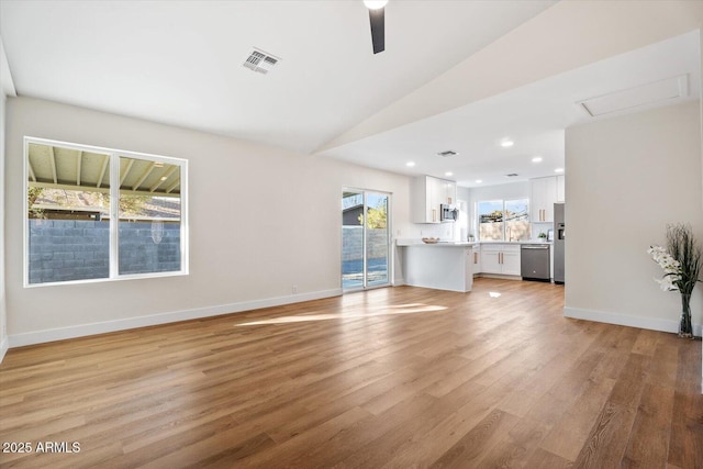 unfurnished living room featuring vaulted ceiling, ceiling fan, and light hardwood / wood-style floors