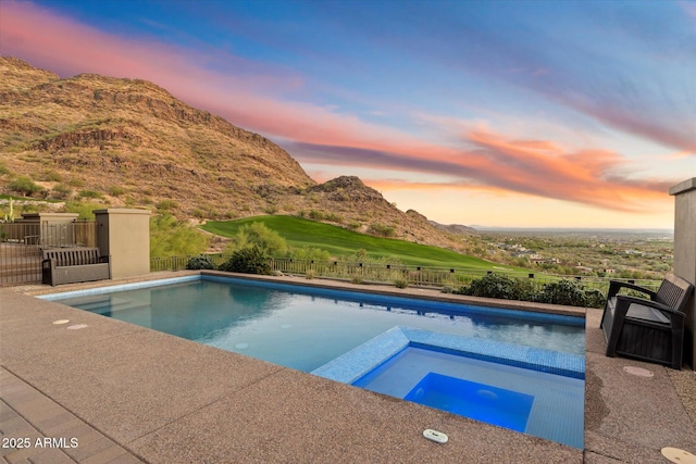 view of pool featuring a hot tub, fence, a mountain view, and a fenced in pool