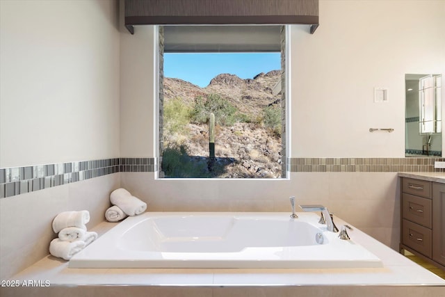 bathroom with a mountain view, a bath, and vanity