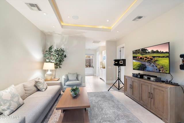 living room featuring light tile patterned floors, visible vents, a tray ceiling, and recessed lighting