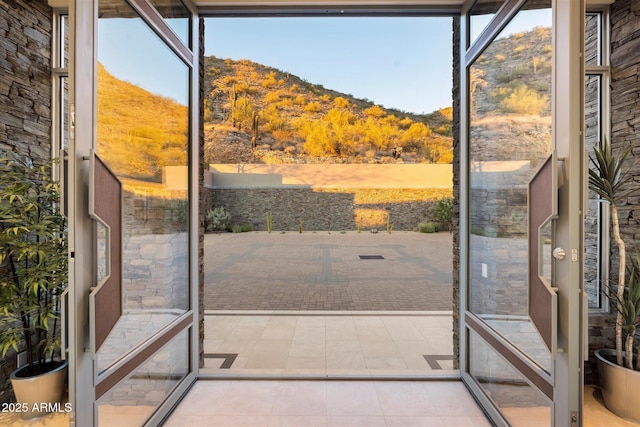 entryway with light tile patterned flooring and a mountain view