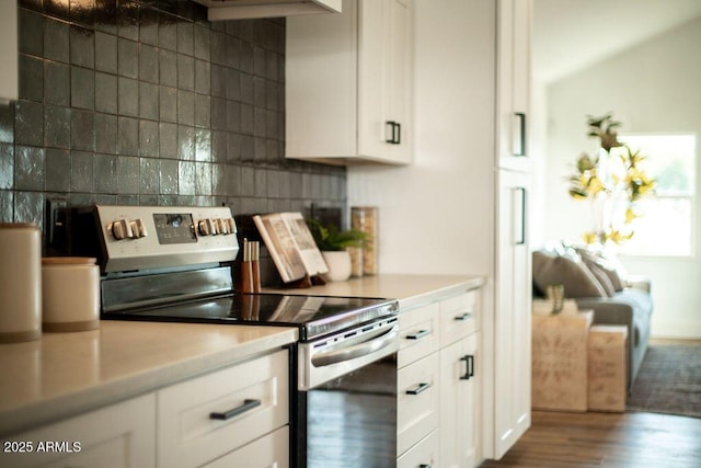 kitchen with backsplash, white cabinets, dark wood-type flooring, and stainless steel electric range