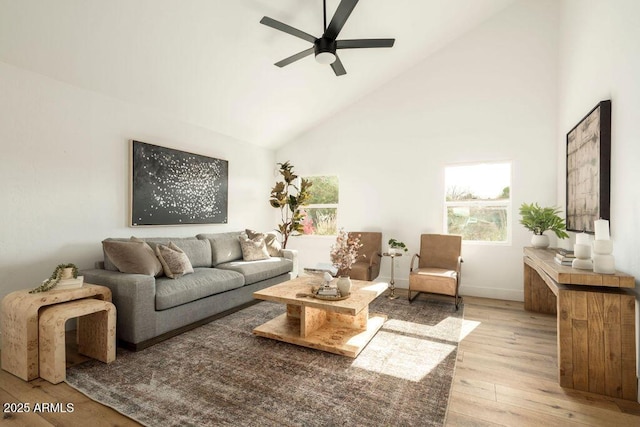 living room featuring ceiling fan, high vaulted ceiling, and light hardwood / wood-style flooring