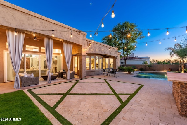 patio terrace at dusk featuring an outdoor living space, a fenced in pool, and ceiling fan