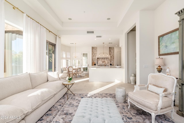 living room featuring a tray ceiling and a chandelier