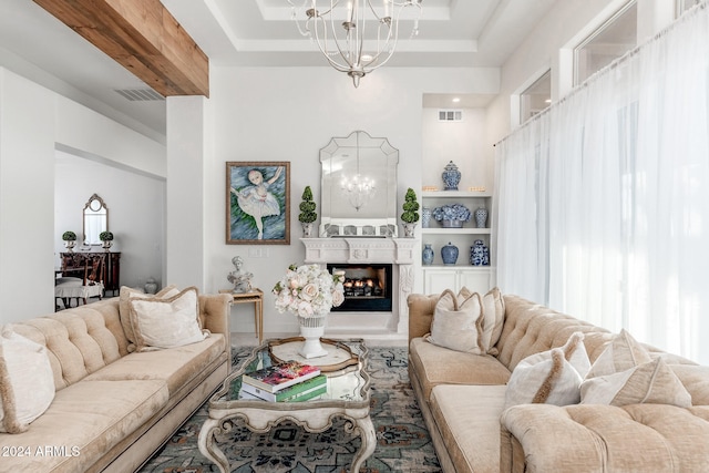 living room featuring an inviting chandelier and a raised ceiling