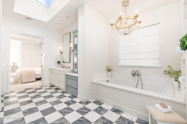 bathroom featuring a tub to relax in, a skylight, vanity, and a notable chandelier