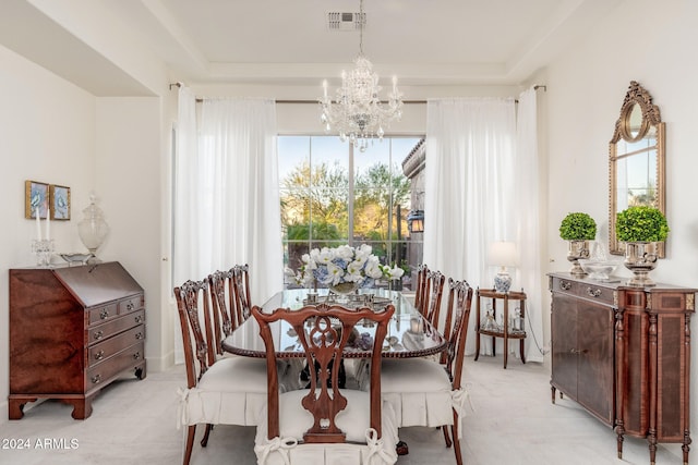 dining area with a tray ceiling and a notable chandelier